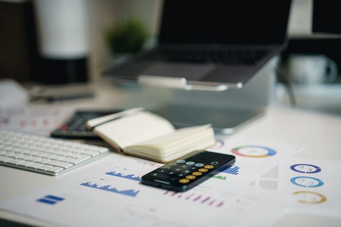 A working desk with printed charts and a calculator