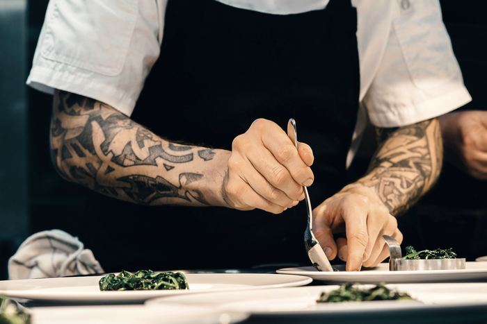 A chef plating a dish in a restaurant kitchen