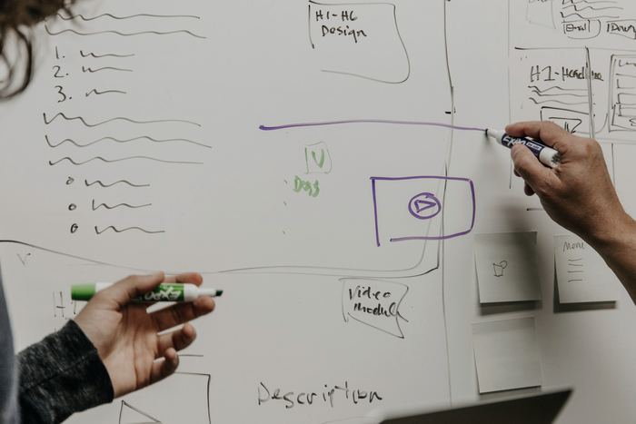 Two people drawing on whiteboard