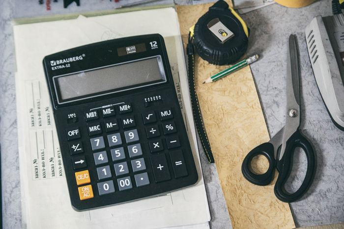 A calculator and office supplies laid out on a desk