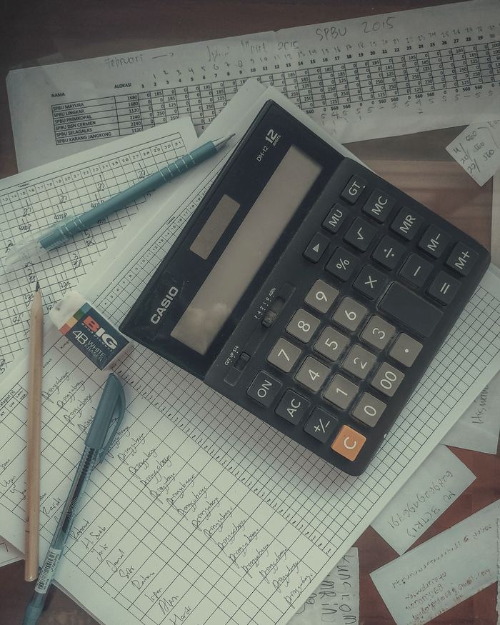 A calculator sitting on top of a pile of papers