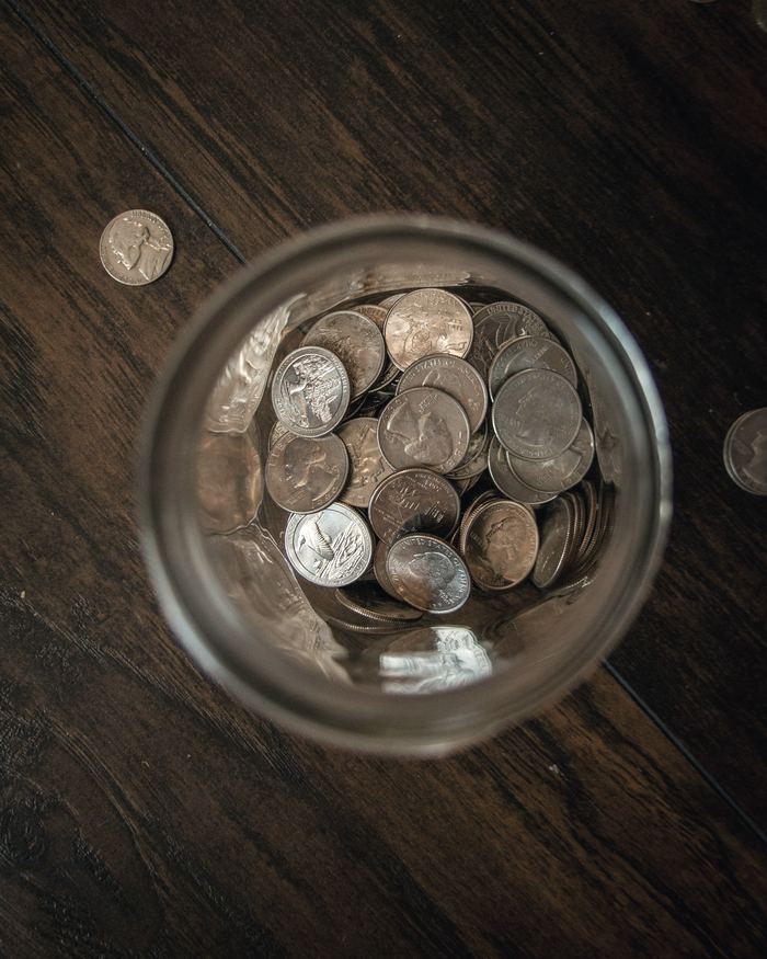 Silver round coins on clear glass jar