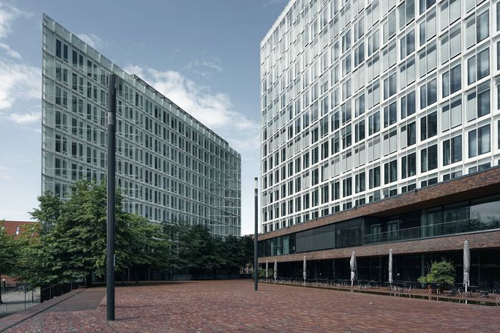 Modern glass buildings with trees and outdoor seating