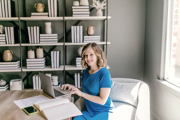Smiling woman working on laptop at a desk