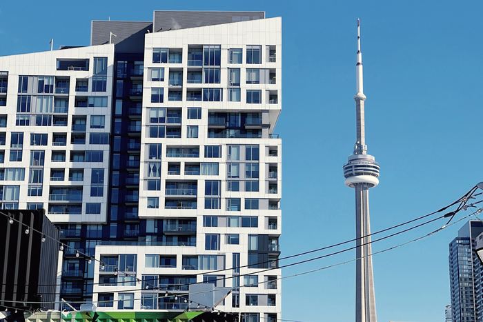 A Toronto condo tower with the CN Tower behind it