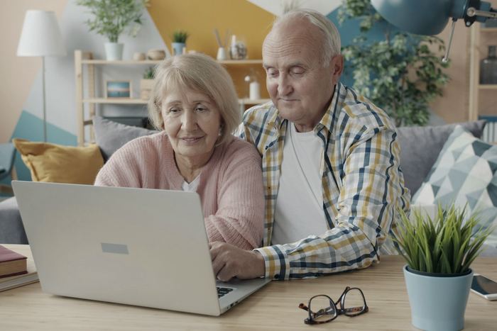 An older couple looking at a laptop together at home