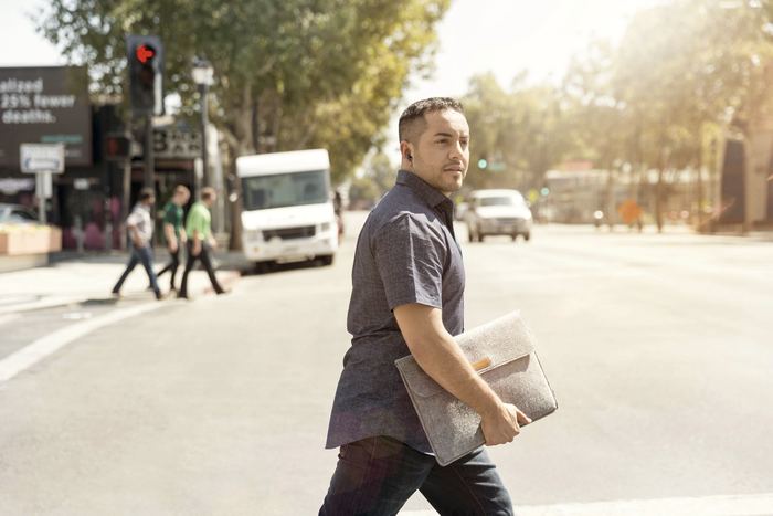 Man holding bag walking on road