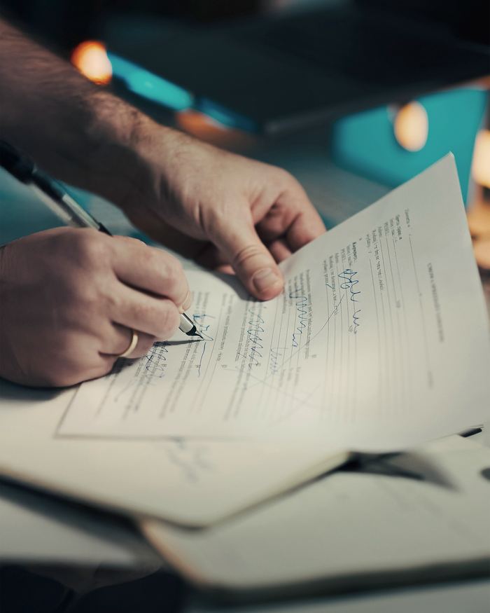 Man signing a document with a pen